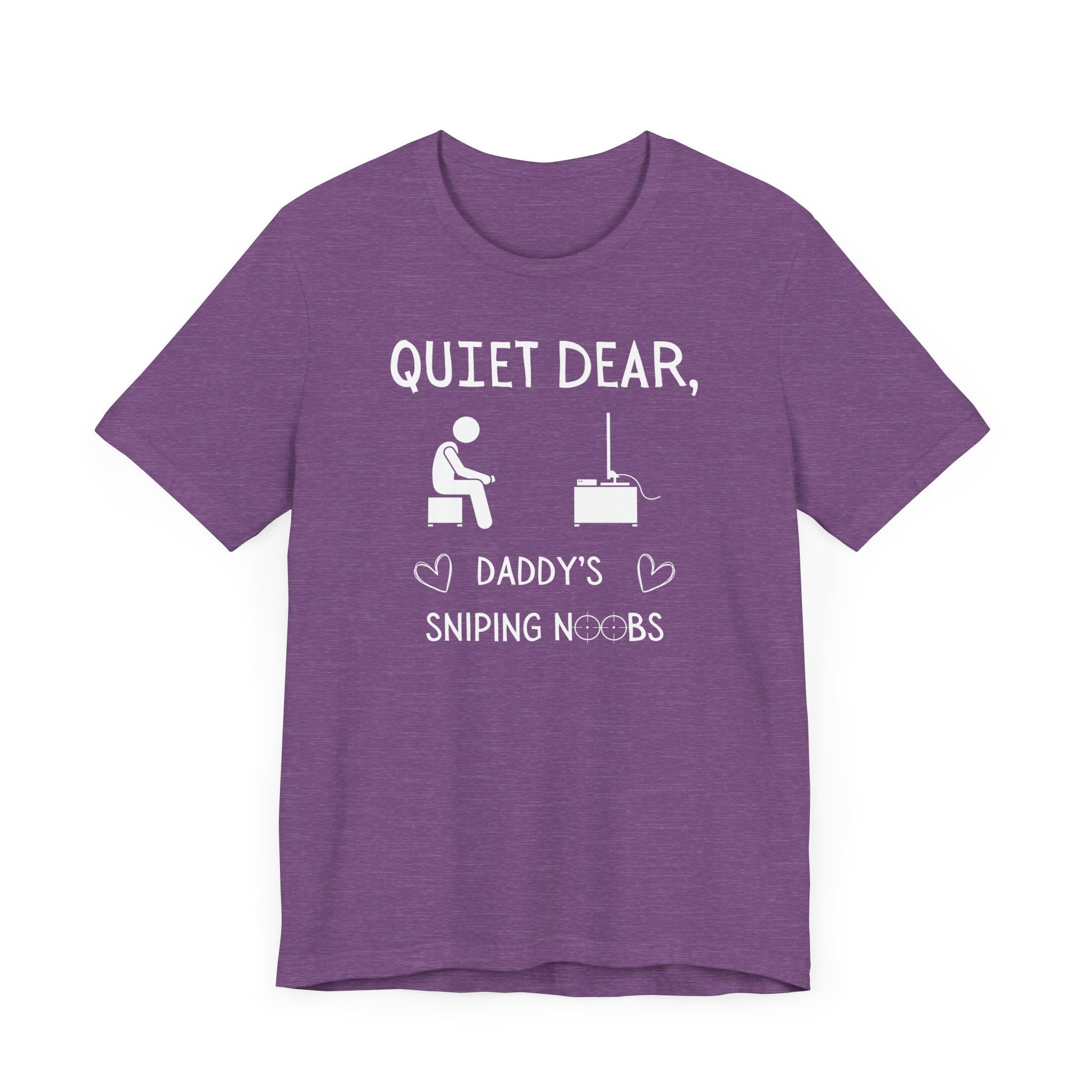 A flat image of a purple heather t-shirt that reads Quiet Dear, Daddy's Sniping Noobs in white text. The lower text is framed by two hearts, and the O's are in the shape of sniper scopes. In the center of the shirt is an image of a person holding a controller sitting across from a TV.