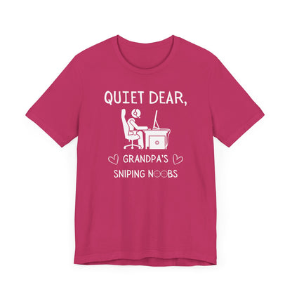 A flat image of a berry pink t-shirt that reads Quiet Dear, Grandpa's Sniping Noobs in white text. The lower text is framed by two hearts, and the O's are in the shape of sniper scopes. In the center of the shirt is an image of a person at a desk with a gaming PC.