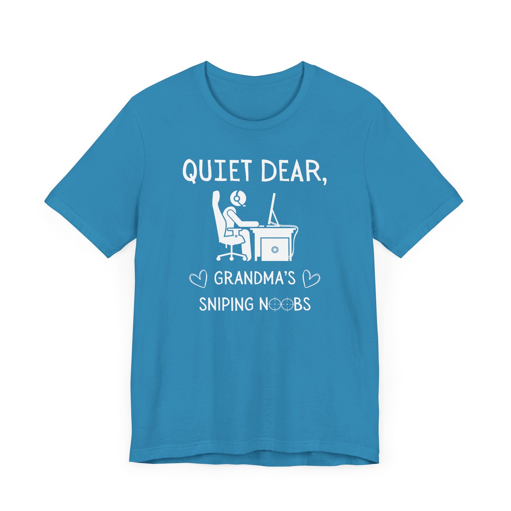 A flat image of an aqua t-shirt that reads Quiet Dear, Grandma's Sniping Noobs in white text. The lower text is framed by two hearts, and the O's are in the shape of sniper scopes. In the center of the shirt is an image of a person at a desk with a gaming PC.