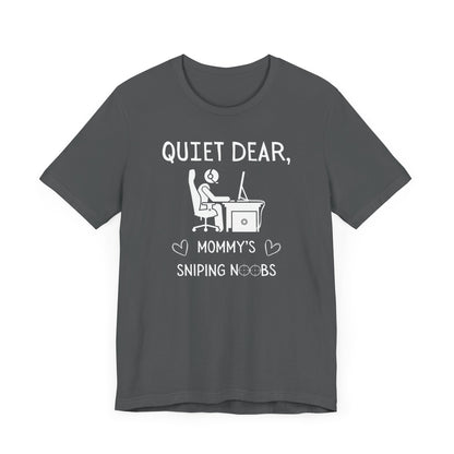 A flat image of a gray t-shirt that reads Quiet Dear, Mommy's Sniping Noobs in white text. The lower text is framed by two hearts, and the O's are in the shape of sniper scopes. In the center of the shirt is an image of a person at a desk with a gaming PC.